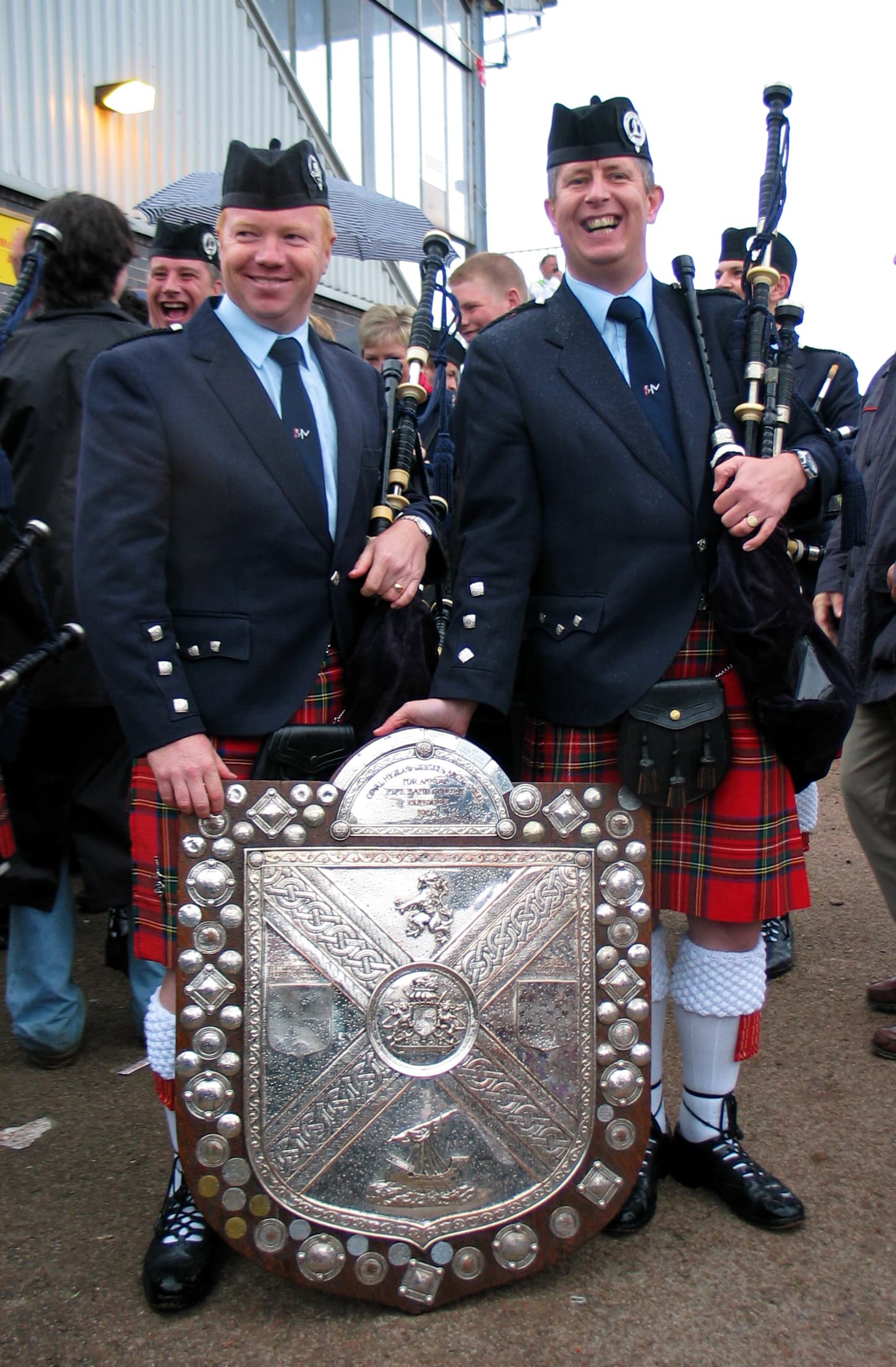 Craig McIntosh with a fellow piper and the Cowal Highland Gathering championship shield